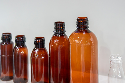 Glass bottles and jars of different shapes and sizes on white background