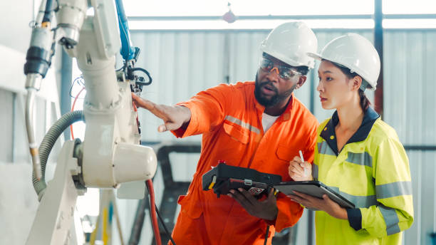 diversity professional engineer training and discussing in robot development plant - manufaturando imagens e fotografias de stock