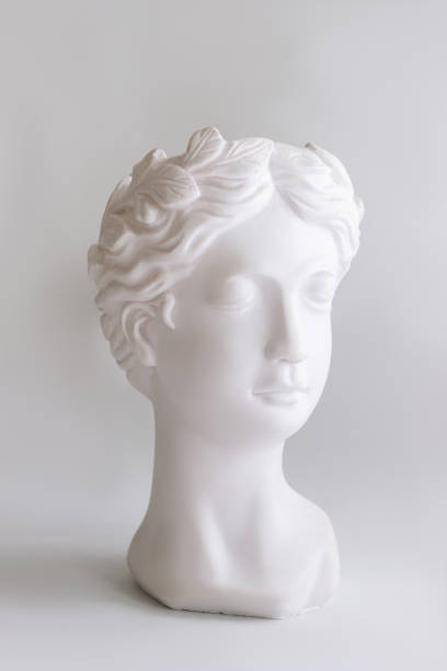 istock White plaster female antique statue's head on a gray background. Vertical shot 1423993813