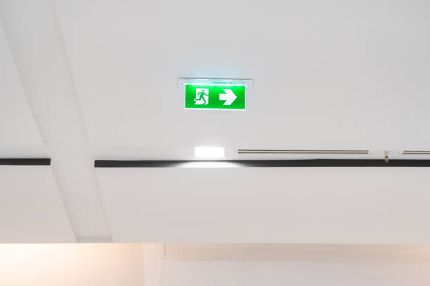 istock White neon sign depicting a fire exit with green background hangs from the ceiling. 1423995224