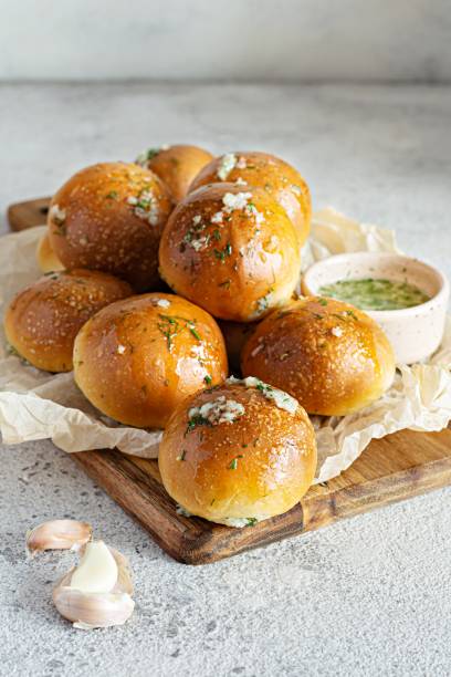 istock Freshly baked buns (pampushki) with garlic and dill for the first course (soup) on a baking tray. National Ukrainian dish, food. Selective focus. 1423995572