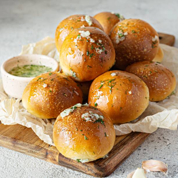 istock Freshly baked buns (pampushki) with garlic and dill for the first course (soup) on a baking tray. National Ukrainian dish, food. Selective focus. 1423995574
