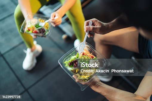 istock Top view Asian man and woman healthy eating salad after exercise at fitness gym. 1423997728