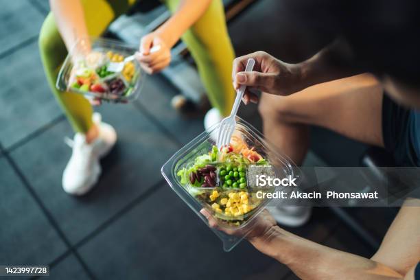 Top View Asian Man And Woman Healthy Eating Salad After Exercise At Fitness Gym Stock Photo - Download Image Now