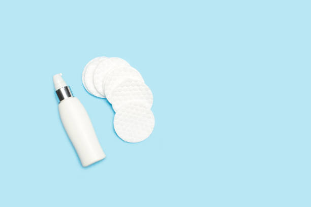 istock Round cotton pads and a plastic bottle on a light blue background 1423998577