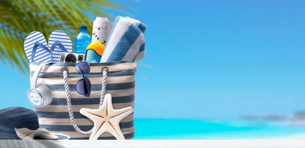 istock Beach bag with accessories and tropical beach 1424000113