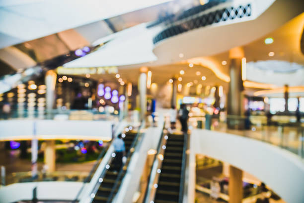 istock Abstract blurred image  people in motion in escalators at the modern shopping mall for banner advertising background 1424000324