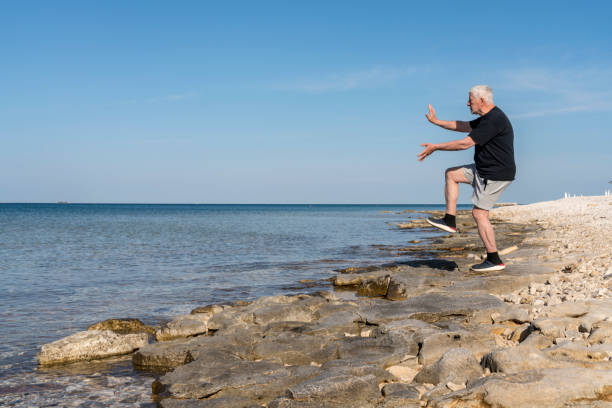 istock Men exercising karate on stony beach early in the morning 1424002315