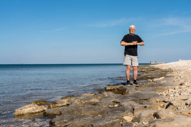 istock Men exercising on stony beach early in the morning 1424002399