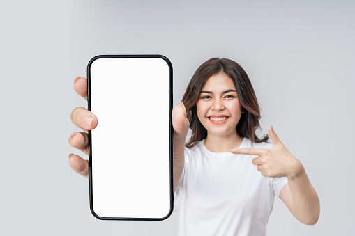 Pantalla en blanco del teléfono inteligente con espacio vacío para la aplicación móvil en la pantalla en la mano alegre mujer asiática. photo