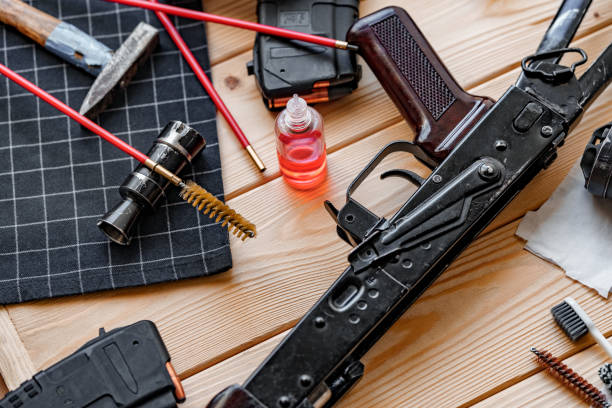 istock Black disassembled shotgun and cleaning tools on wooden table . 1424006958