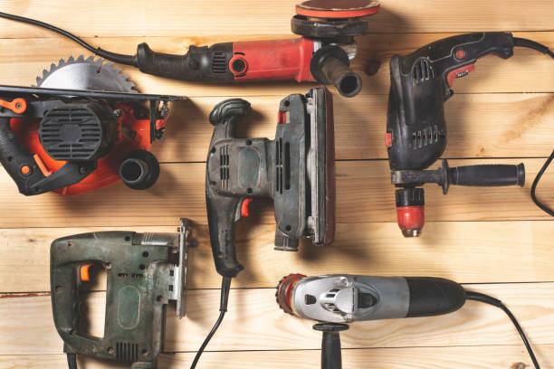 istock Construction carpentry tools. Electric corded circular saw, jigsaw, drill on wooden background 1424007041