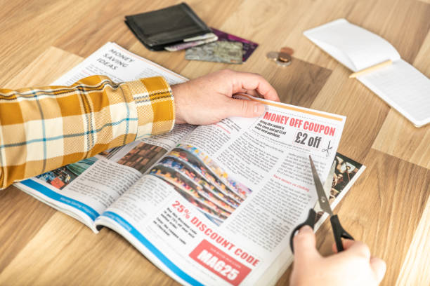 istock Cutting out a money saving discount coupon from a magazine 1424007053