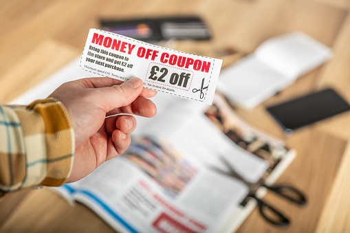 Holding a discount coupon cut from a magazine