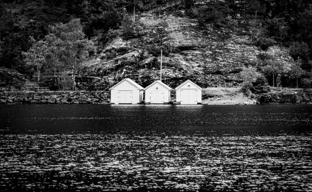 Geirangerfjord near Hellesylt in Norway.  Three boathouses central in the frame.