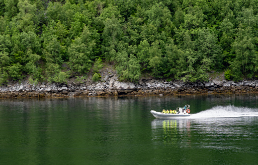 Geirangerfjord near Hellesylt in Norway.  There is a Rigid inflatable boat on the Fjord.
