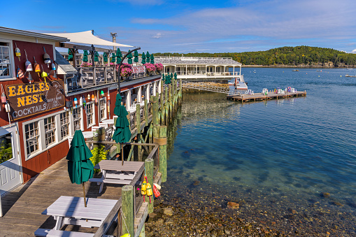 Bar Harbor, Maine, USA - October 2, 2021: A wide-angle view of a commercial pier at shore of Frenchman Bay on a sunny Autumn morning.