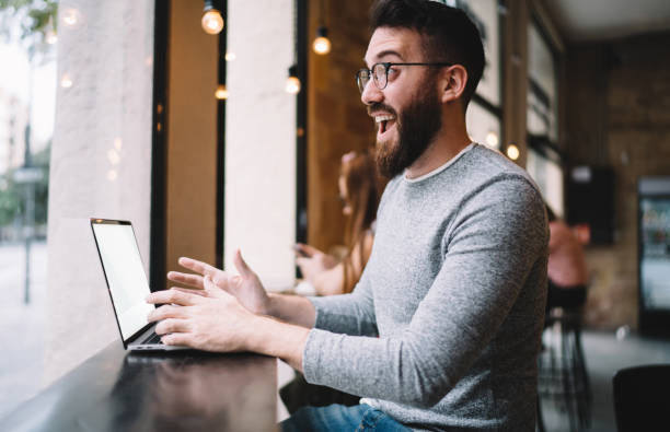 istock Joyful male remote worker watching laptop screen in cafe 1424013332
