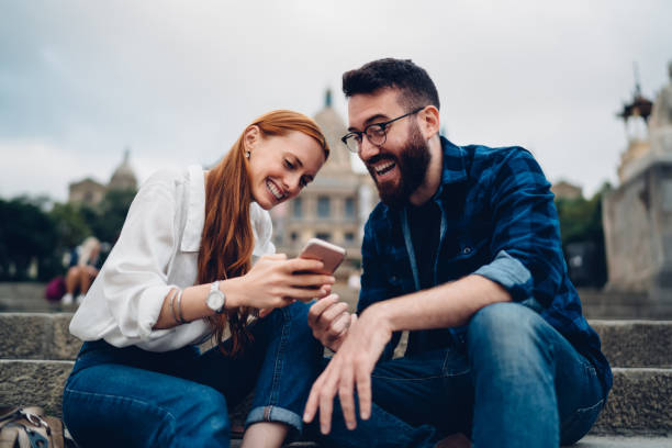 istock Young couple watching video on smartphone 1424013377