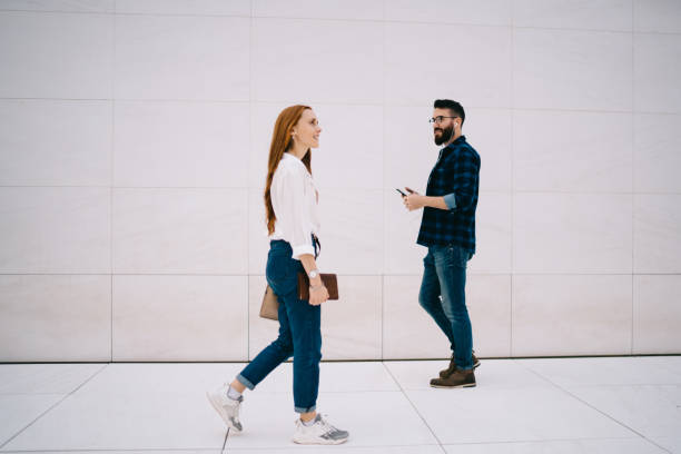 istock Modern people passing each other on street 1424013471