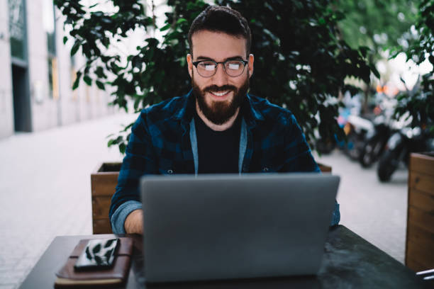 istock Cheerful employee using laptop on street 1424013991