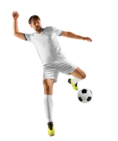 Full length of aged 18-19 years old with black hair african ethnicity teenage boys soccer player kicking in front of white background who is laughing and holding soccer ball and playing soccer - sport and using sports ball