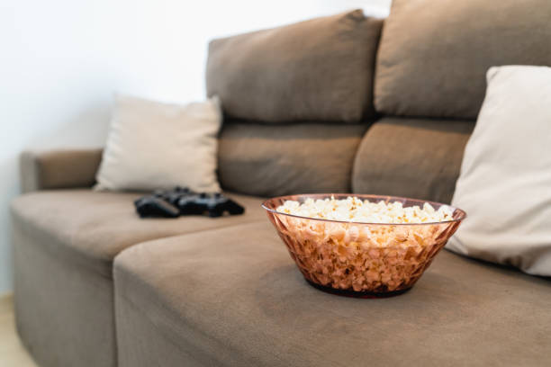 istock Popcorn and controls on the sofa for meeting friends 1424025830