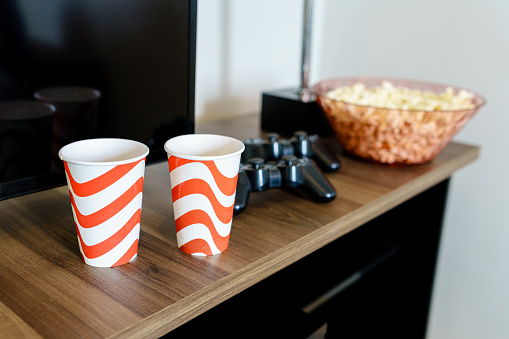 Cups, video game controllers and popcorn for meeting friends.