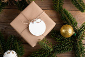 Blank round Christmas gift tag mockup with present box, product label mockup, with natural fir tree branch