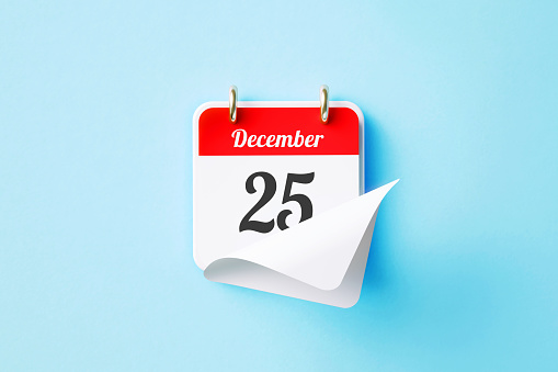 December 25 written red calendar sitting on blue background. Horizontal composition with copy space. Directly above. Christmas concept.
