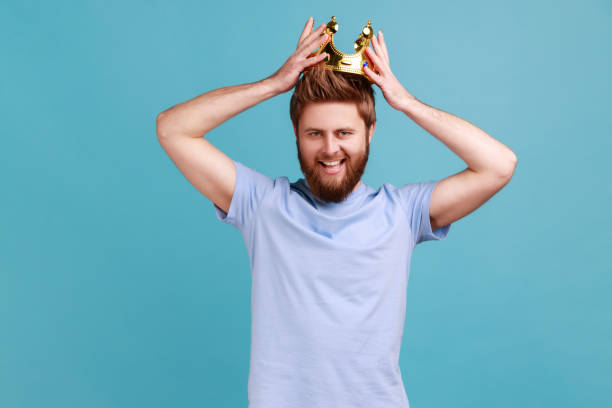 istock Man wearing golden crown, imagining promotion at work to position, looking with arrogance. 1424031452