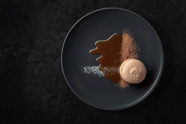 istock Macaroon on a black plate garnished with chocolate sauce and cocoa powder. 1424032251