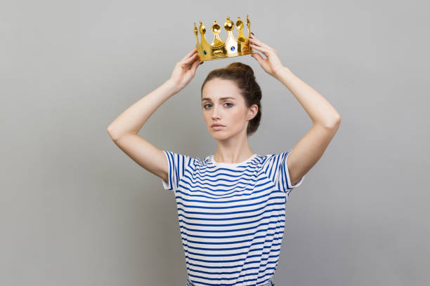 istock Woman in golden crown looking with arrogance and confidence, privileged status. 1424032276