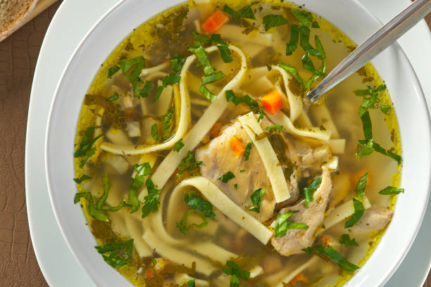 istock Chicken noodle soup with parsley and vegetables in a white plate 1424032833