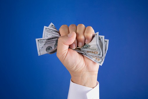 Crumpled one hundred American dollar in businessman hand