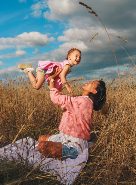 彼女の小さな赤毛の娘と遊んでいるラテンの笑顔の女性 - native american baby love mother ストックフォトと画像