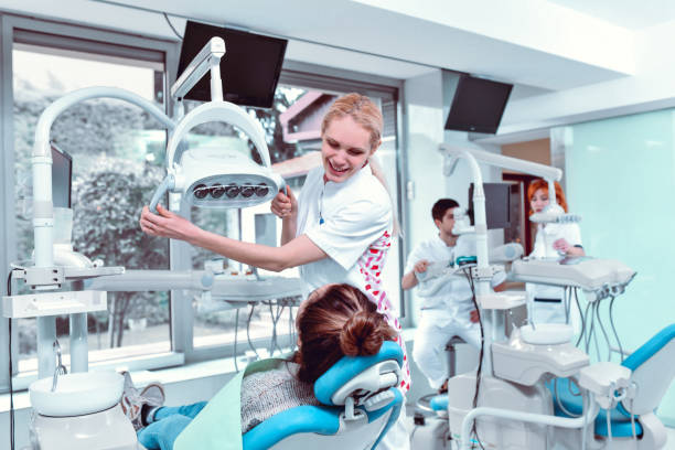 istock Smiling Female Dentist Positioning Light Towards Patient 1424058579