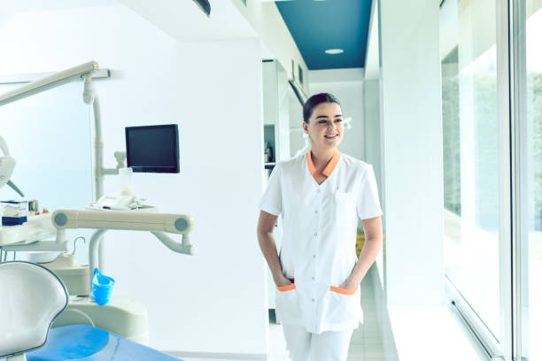 istock Smiling Female Dentist Inspecting Her Workplace 1424058598