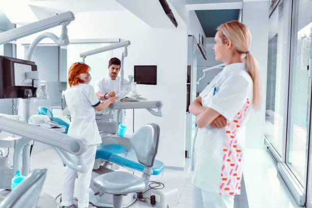 istock Blond Female Dentist Inspecting Colleagues Work 1424059311