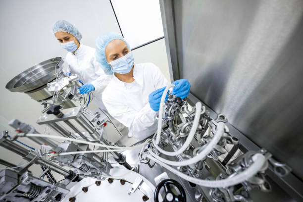 istock Two fully equipped coworkers in protective workwear seen in a pharmaceutical laboratory 1424064074
