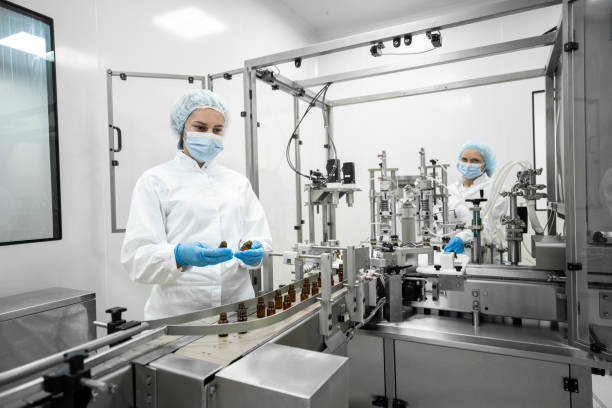 istock Two fully equipped coworkers in protective workwear seen in a pharmaceutical laboratory 1424064284