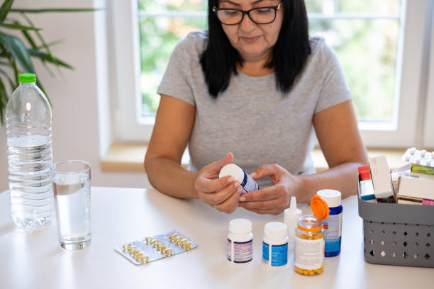 istock Caucasian woman reading label on a pill bottle 1424064754