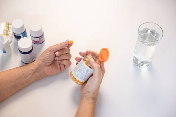 istock High angle view of unrecognizable woman holding a pill 1424065492