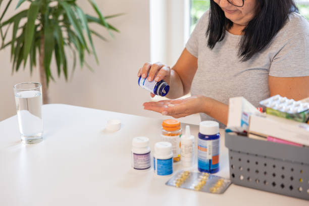 istock Unrecognizable woman taking a pill from a pill bottle 1424065826