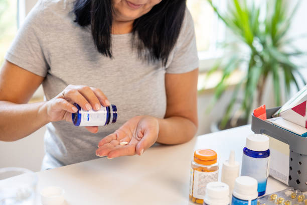 istock Unrecognizable woman taking a pill from a pill bottle 1424065842