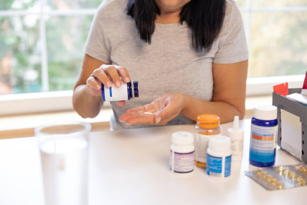 istock Unrecognizable woman taking a pill from a pill bottle 1424065913