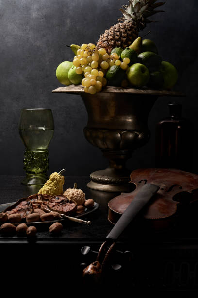istock Still life with fruit in silver vase and old violin 1424066264