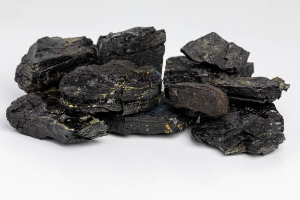 istock Black coal lumps isolated on white background. Fossil fuel, air pollution and coal mining industry concept. 1424077138