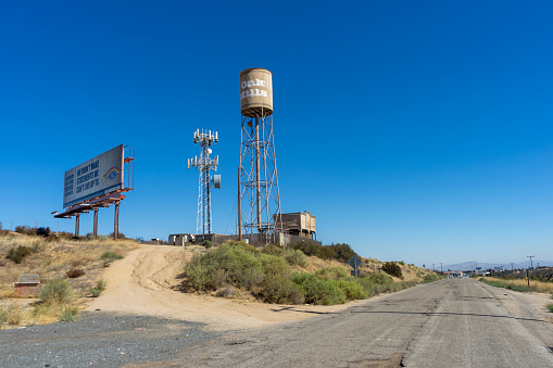Oak Hills, CA, USA – September 14, 2022: On the summit of the Cajon Pass stand a water tower and a cellular tower in the rural town of Oak Hills, California.