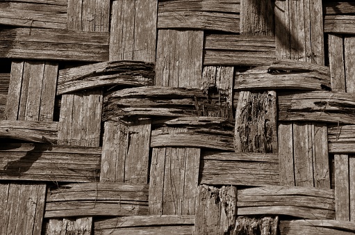 woven bamboo walls of an old building. the surface is damaged, brittle and peeling off. brown rough texture. bamboo wall background